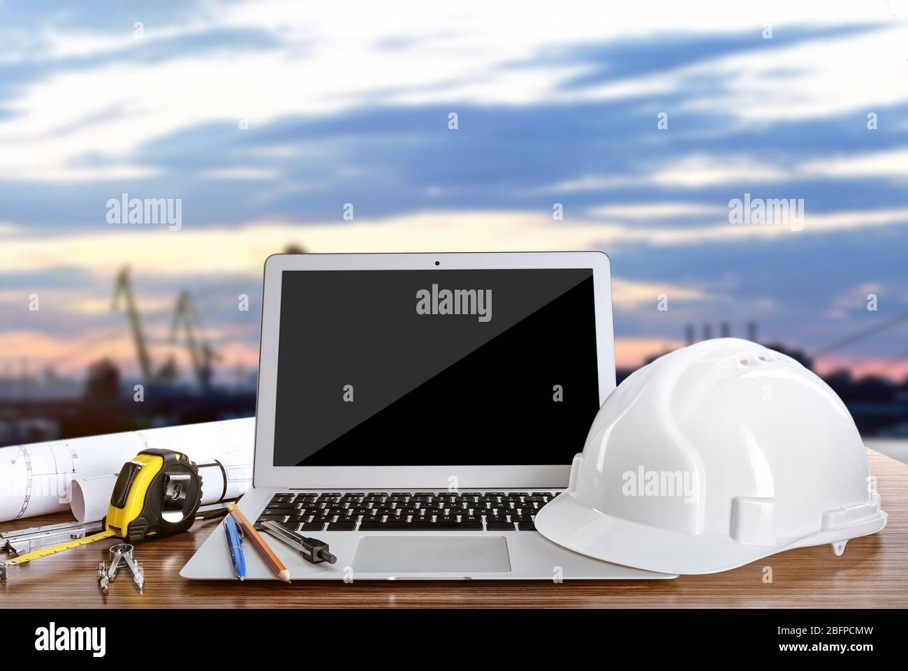 Laptop with construction tools on blue sky background Stock Photo
