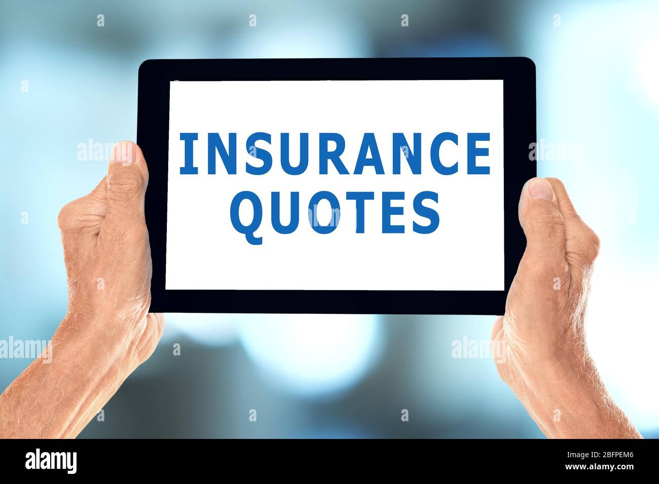 Insurance quotes concept. Elderly man holding tablet with text on screen against blurred background Stock Photo