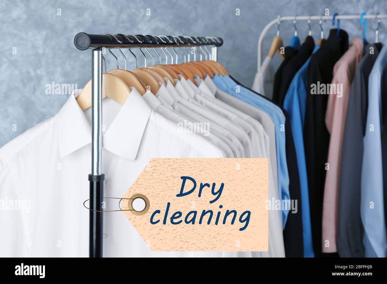 Concept of dry cleaning service. Hangers with clean clothes hanging on rack  Stock Photo - Alamy