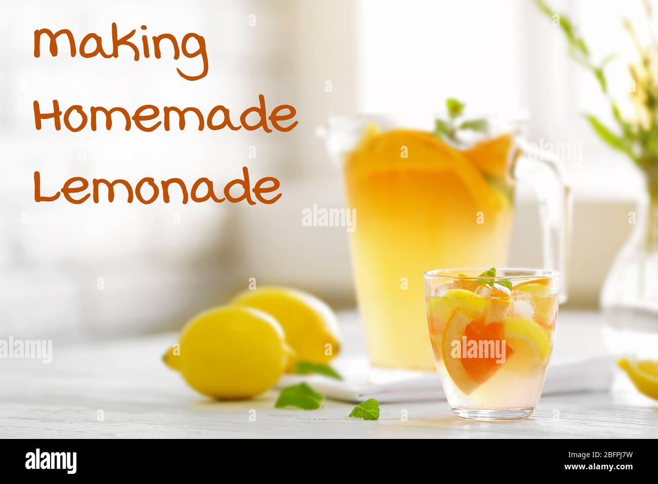 Glass of refreshing drink with lemon and grapefruit on table. Text MAKING HOMEMADE LEMONADE on background Stock Photo