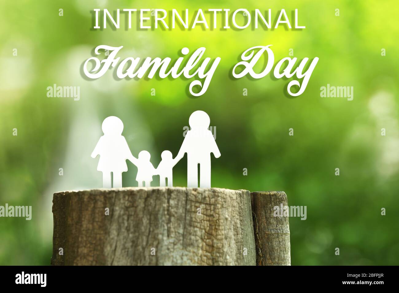 Figure of parents with kids on stump. International family day concept Stock Photo