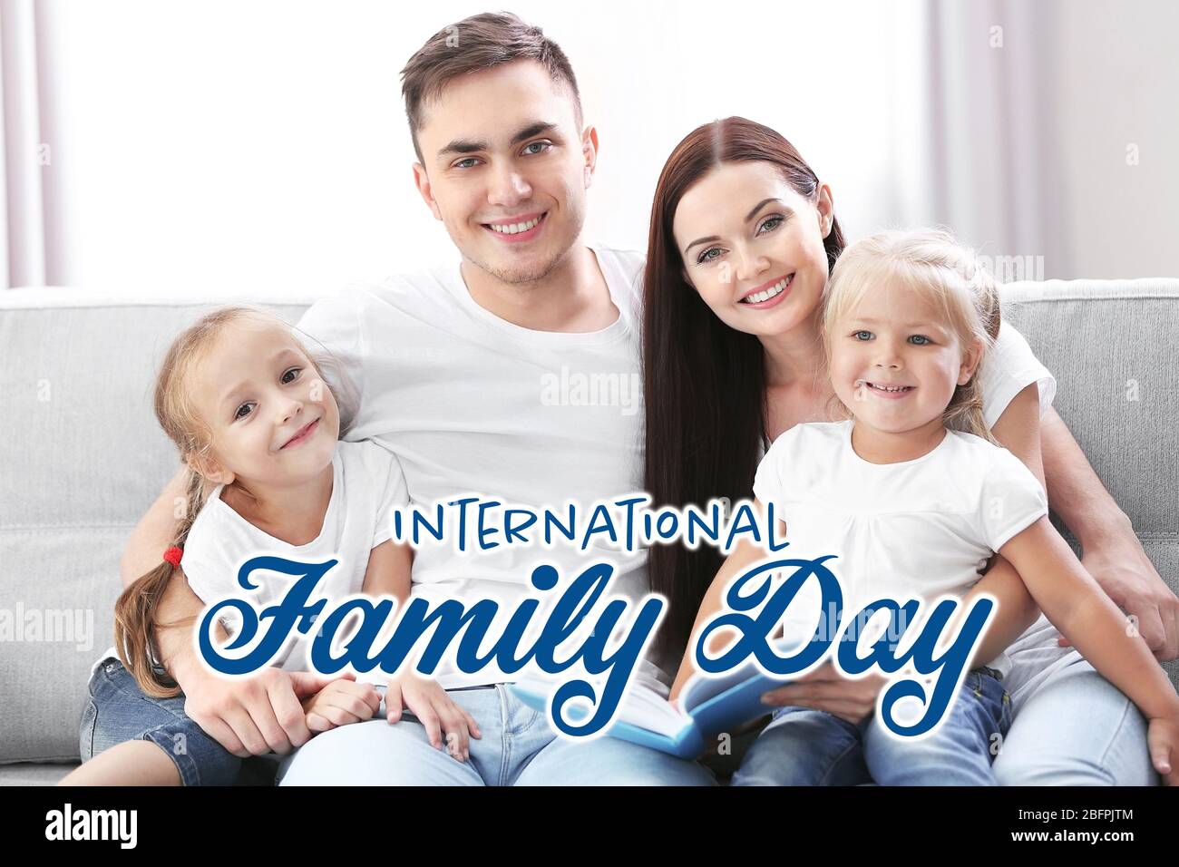 Parents with little children sitting on couch. International family day concept Stock Photo