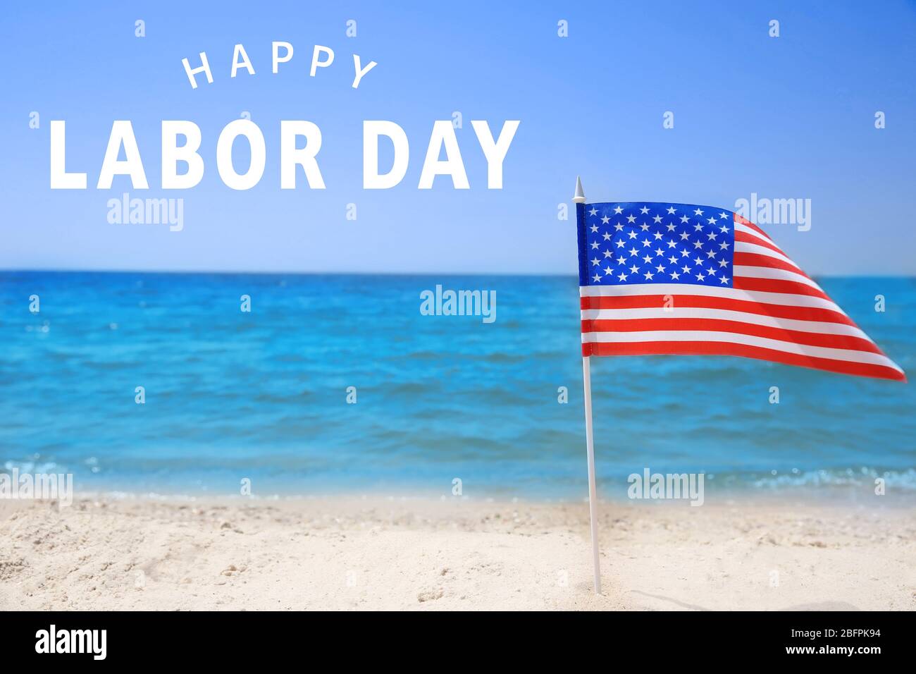 American flag on beach. Text HAPPY LABOUR DAY on background Stock Photo ...