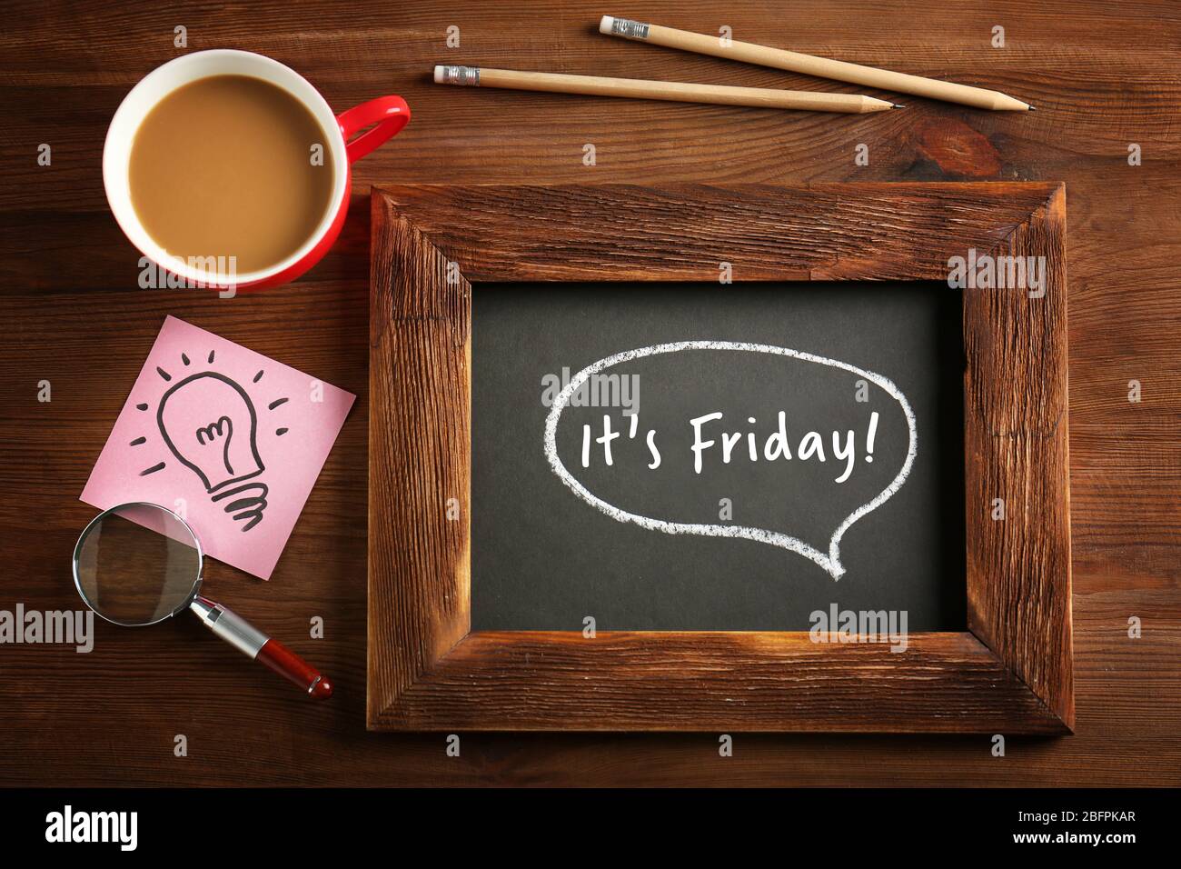 Small chalkboard with text IT'S FRIDAY and cup of coffee on wooden ...