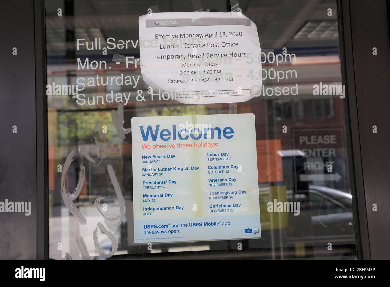 Sign London Terrace Post Office listing reduced hours due to coronavirus, Chelsea, New York City, April 19, 2020 Stock Photo