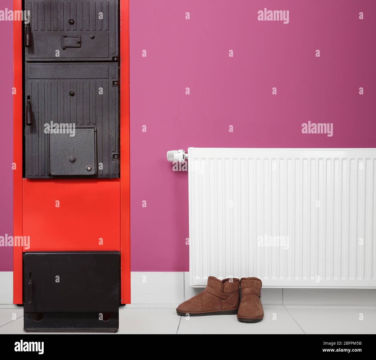 Energy savings concept. Solid fuel boiler and radiator with shoes on ...