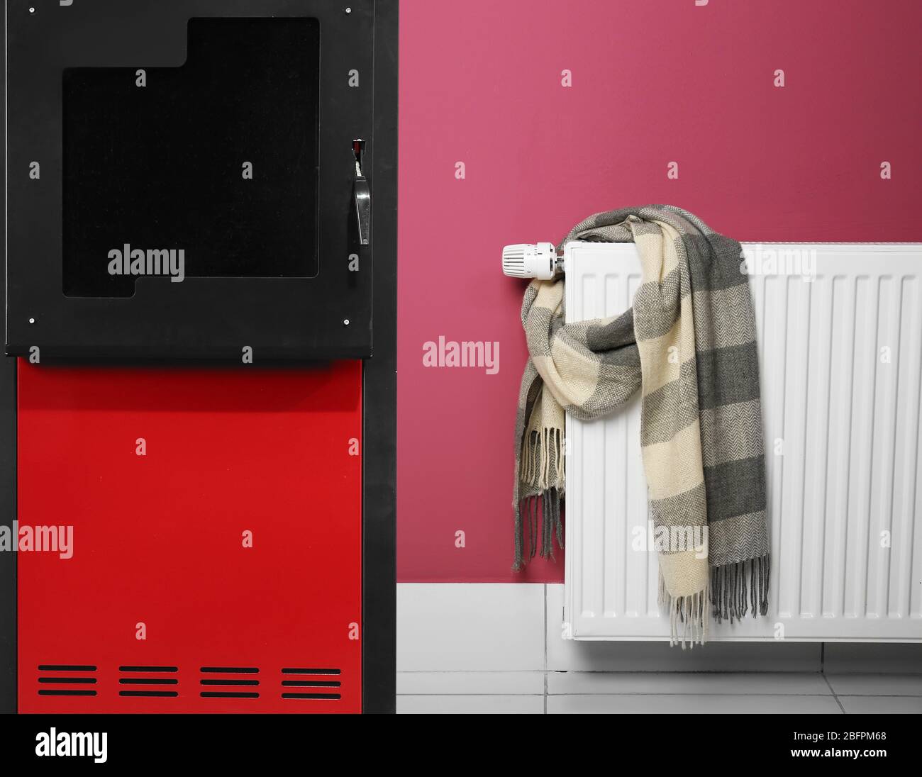 Energy savings concept. Solid fuel boiler and radiator with scarf on ...