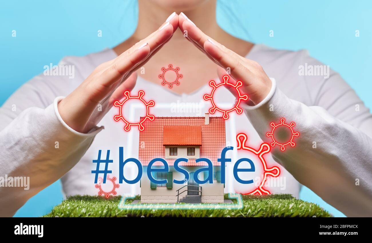 Woman holds hands over a house. Concept of home stay, quarantine, security inside the house. Covid-19 Corona Prevention Measures Stock Photo