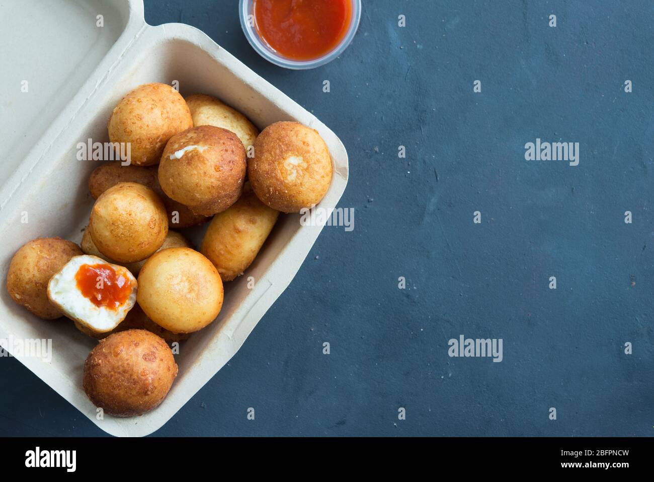 Fried Risotto Arancini stuffed with cheese, served with tomato sauce Stock Photo