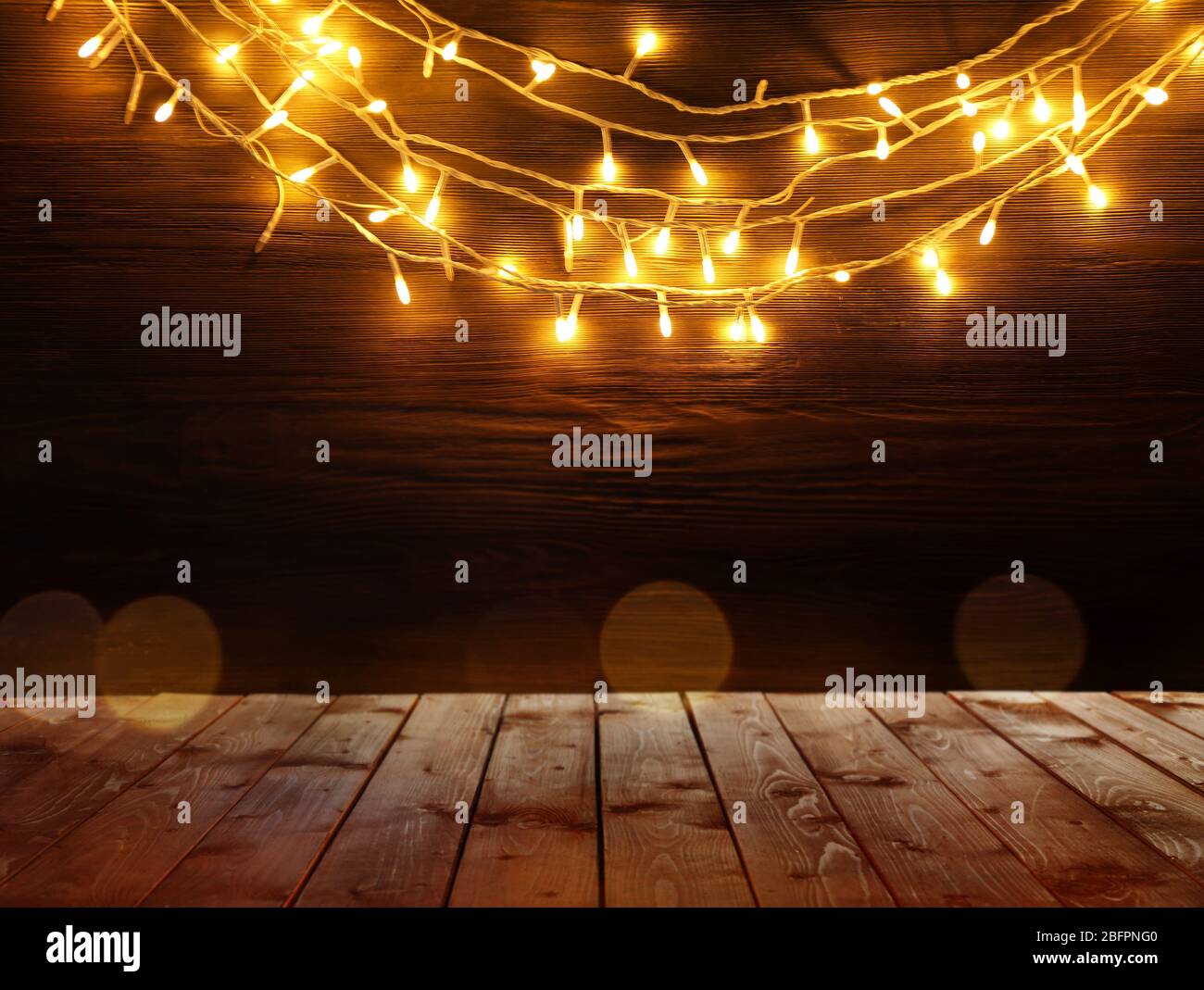 Wooden table and Christmas lights on background Stock Photo - Alamy