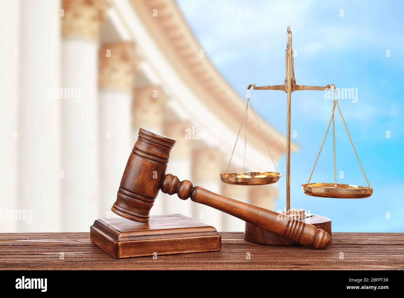 Judge's gavel with scales and courthouse on background. Concept of law