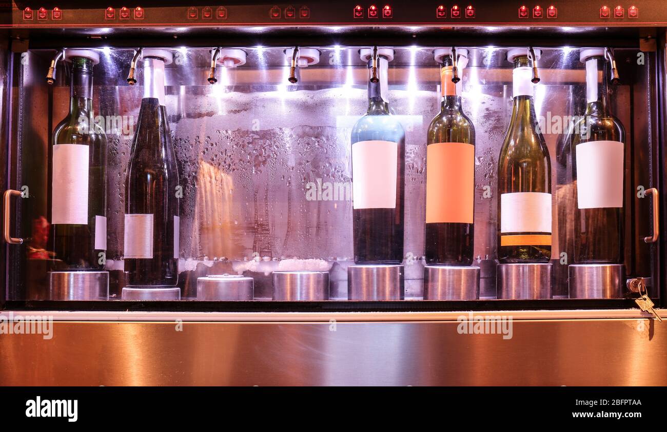 Dispenser with opened bottles of wine in cellar, closeup Stock Photo Alamy