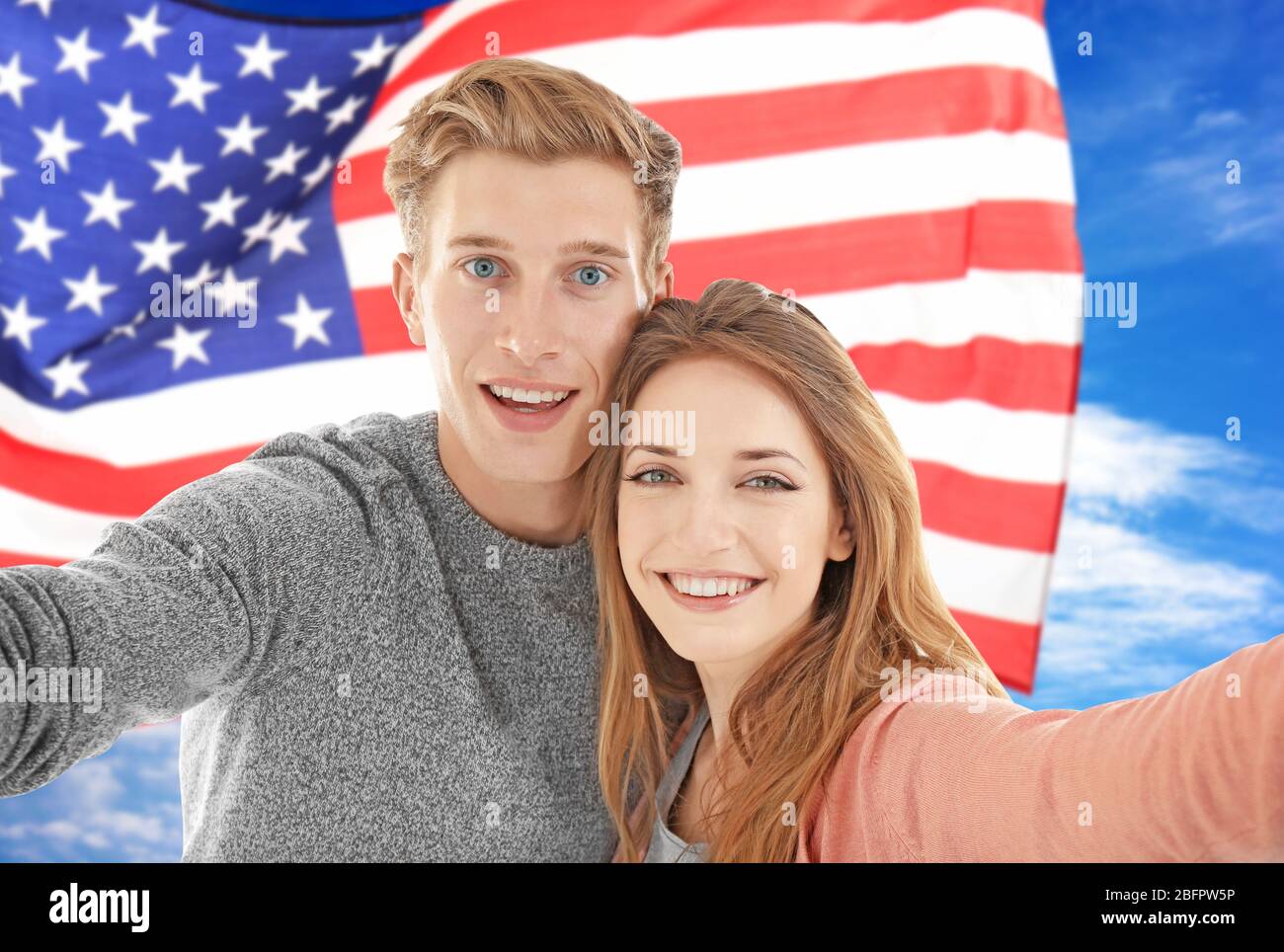 Young couple tacking selfie and USA flag on background Stock Photo