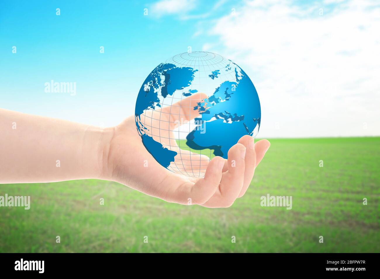 Little child holding globe in hand on landscape background. Concept of aid Stock Photo