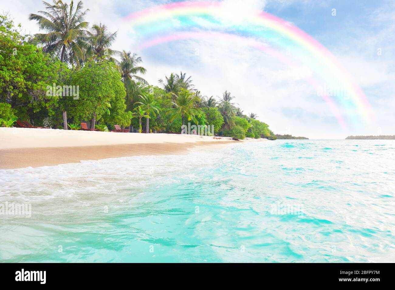 Tropical beach at sea resort and rainbow in sky Stock Photo - Alamy