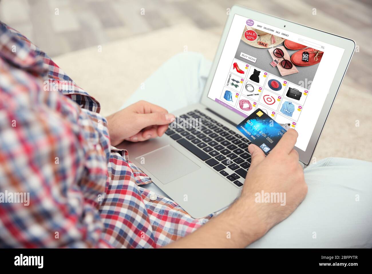 Man using laptop and credit card for internet online shopping at home Stock Photo