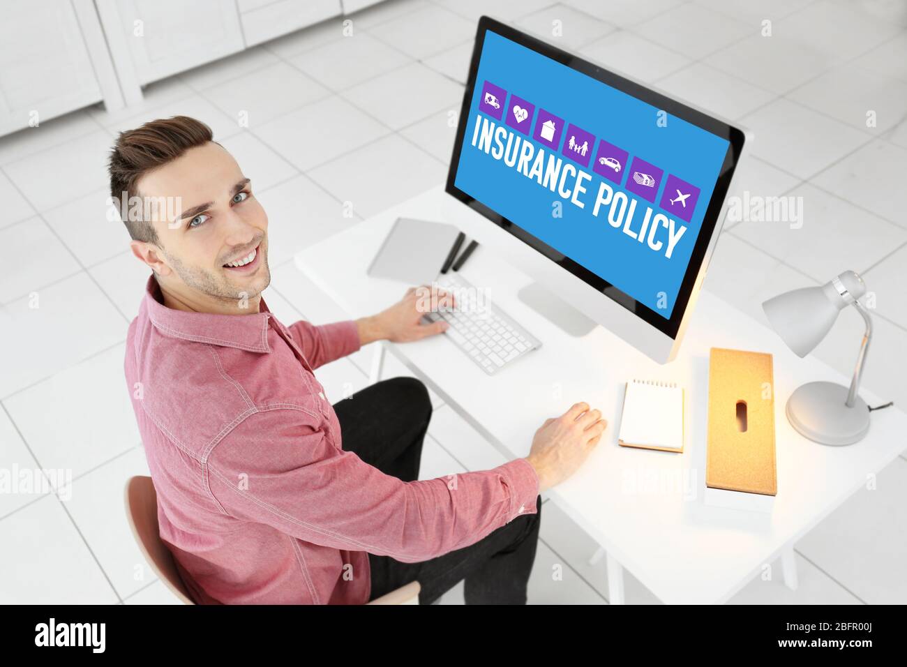 Young man using computer at table. Concept of insurance policy Stock Photo