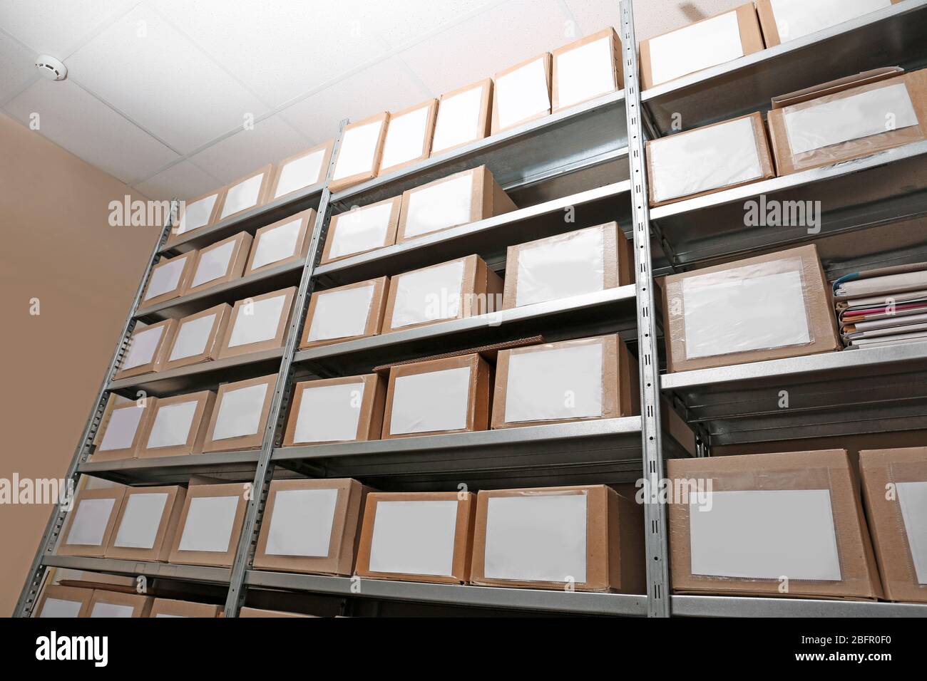 Cardboard boxes with documents on shelving unit in archive Stock Photo