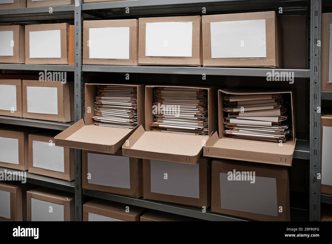 Cardboard boxes with documents on shelving unit in archive Stock Photo