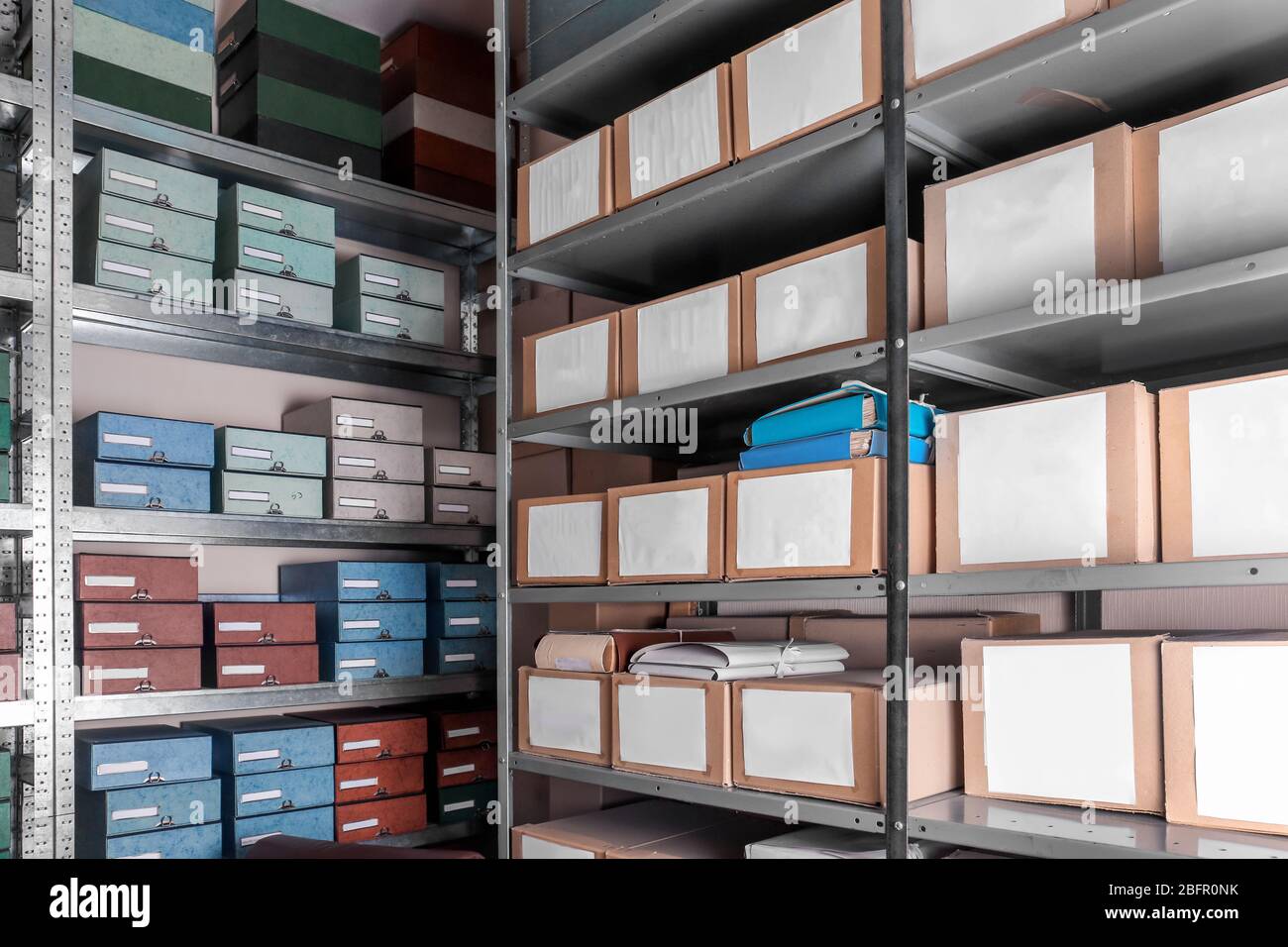 Cardboard boxes with documents on shelving units in archive Stock Photo
