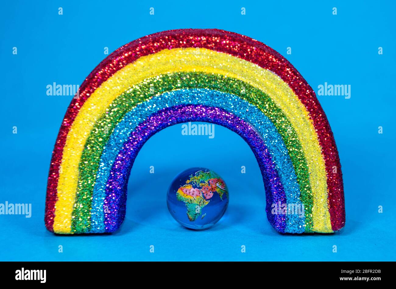 The planet Earth along with a colorful rainbow colored ribbon which signifies many things, such as the Coronavirus pandemic. Stock Photo