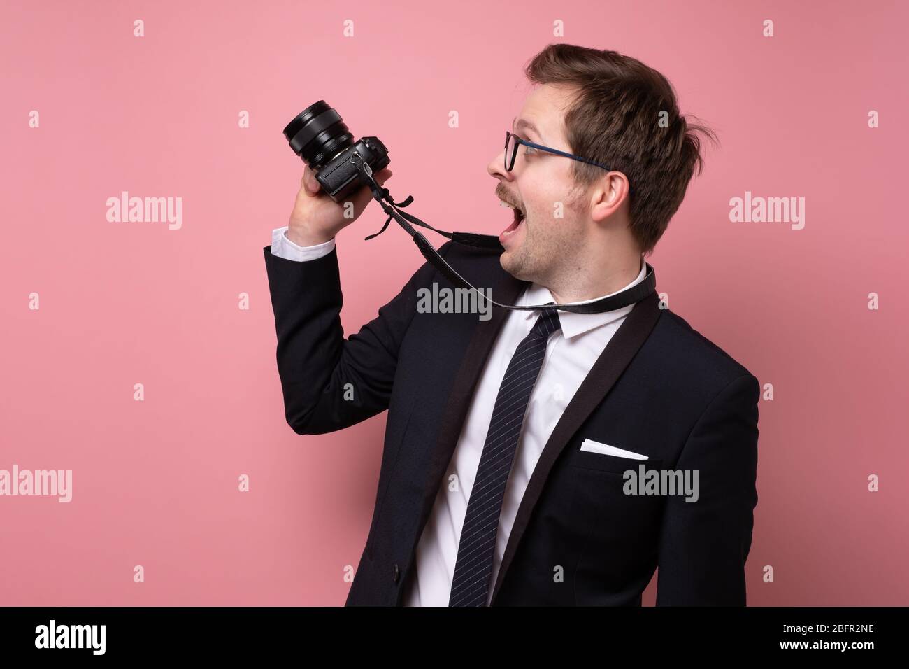 Young photographer taking pictures with digital camera. Studio shot Stock Photo