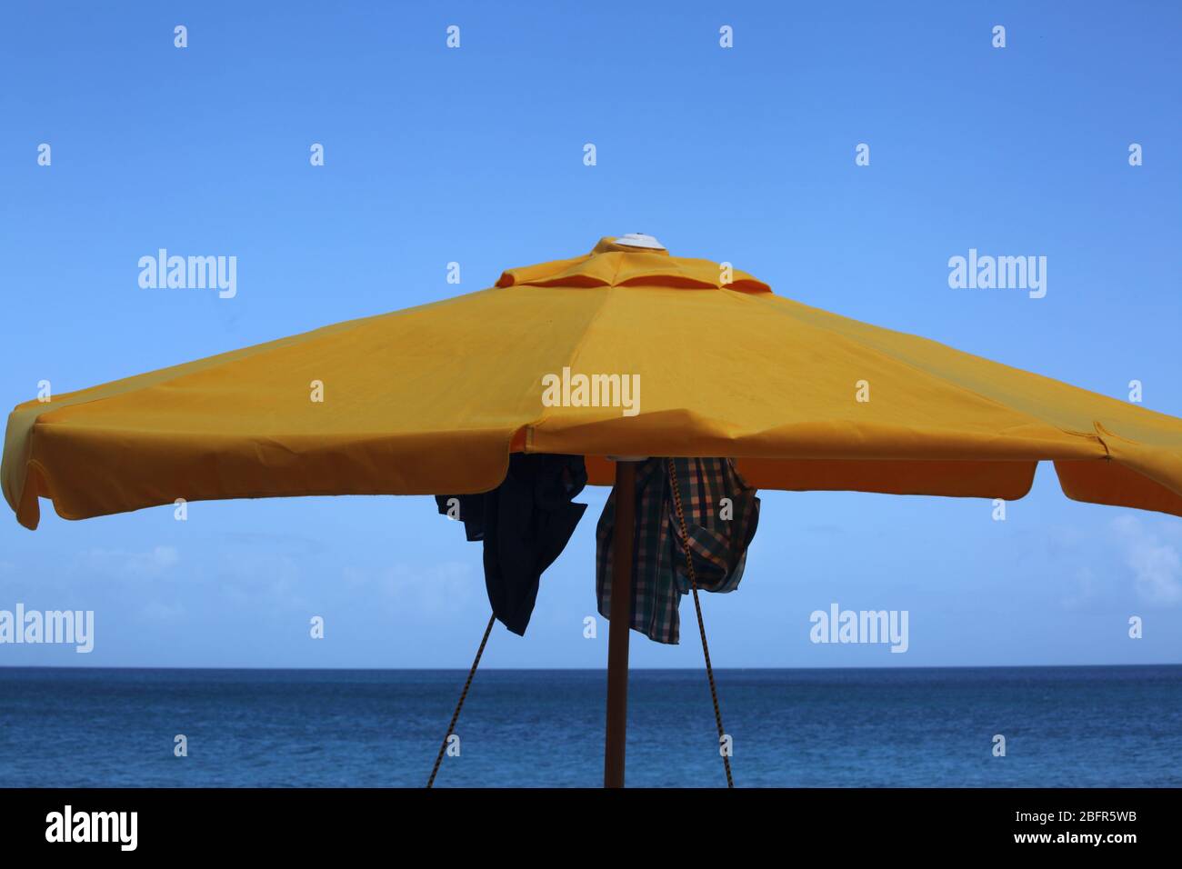 Grand Anse Beach Grenada clothes hanging on Parasol to dry Stock Photo