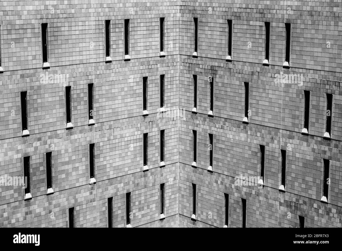 Jail or Prison harsh brick exterior. Thin windows let in a minimum of light and offer maximum security. Stock Photo