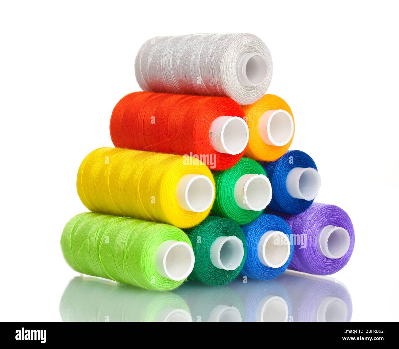 Pyramid of many-coloured bobbins of thread isolated on white Stock ...