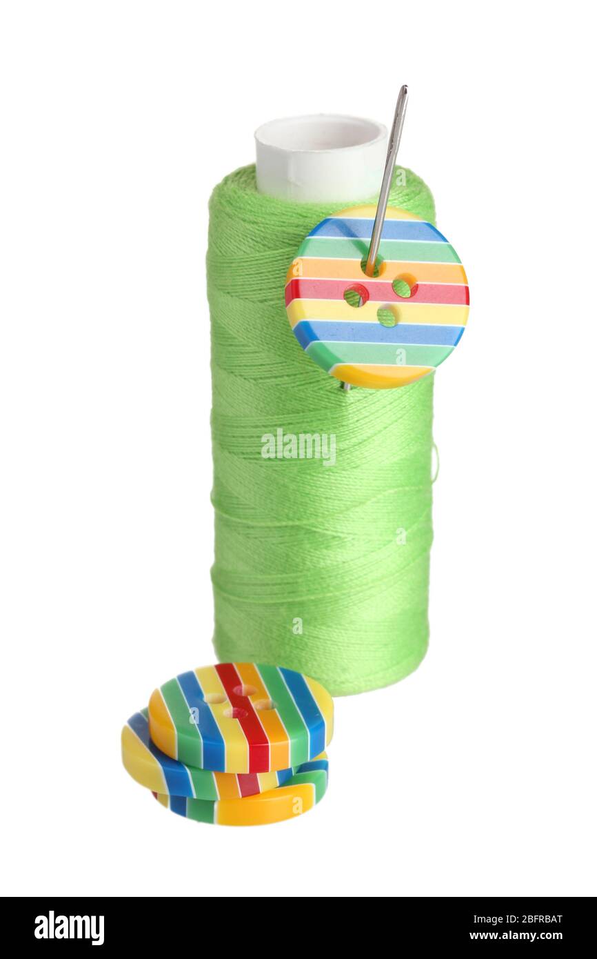 Green bobbin with needle and buttons isolated on white Stock Photo - Alamy