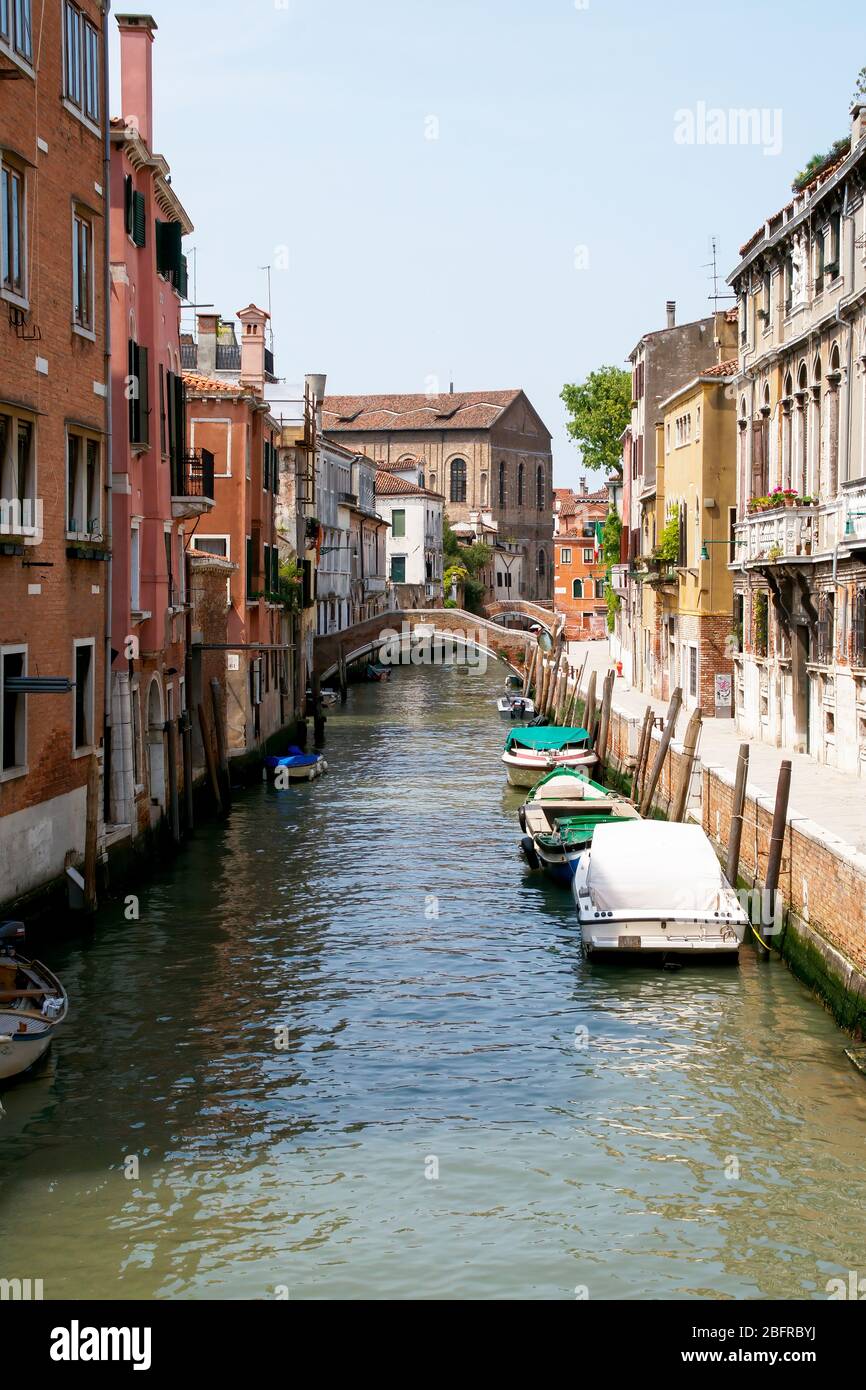 A silent and empty side canal between buildings, residences, and shops. Venice, Italy Stock Photo