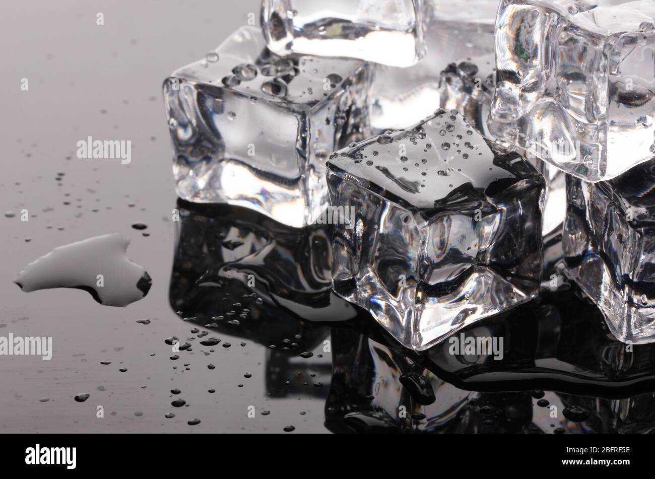 Melting ice cubes on black background Stock Photo - Alamy
