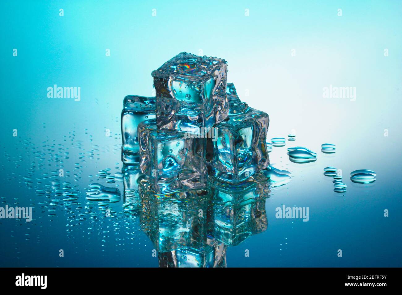 Melting ice cubes on blue background Stock Photo - Alamy