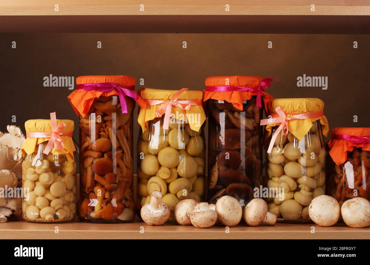 delicious marinated mushrooms in the glass jars, raw champignons and