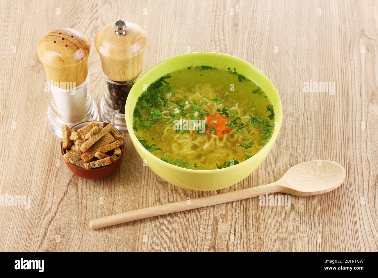 Tasty chicken stock with noodles on wooden background Stock Photo