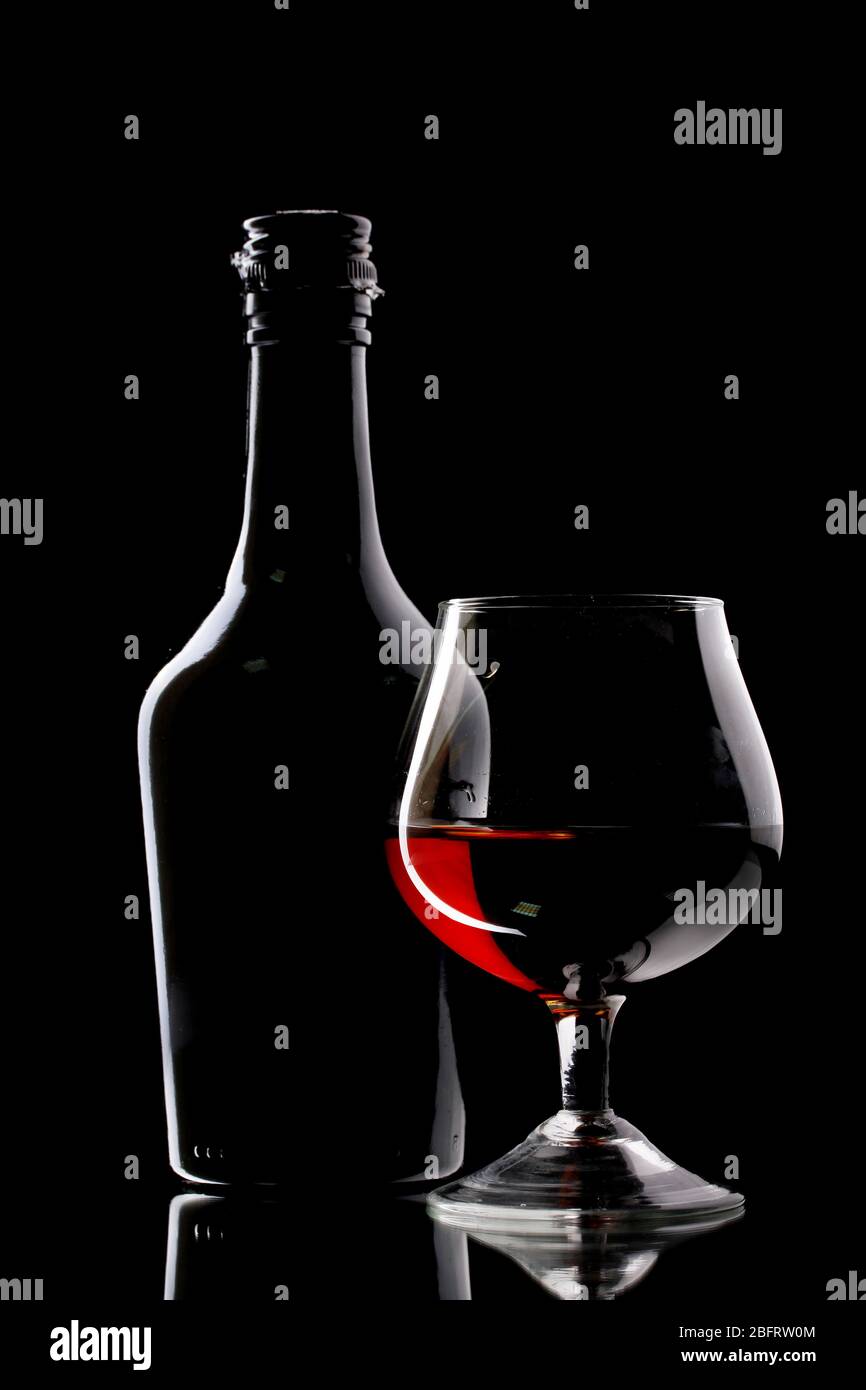Glass of brandy and bottle on black background Stock Photo Alamy