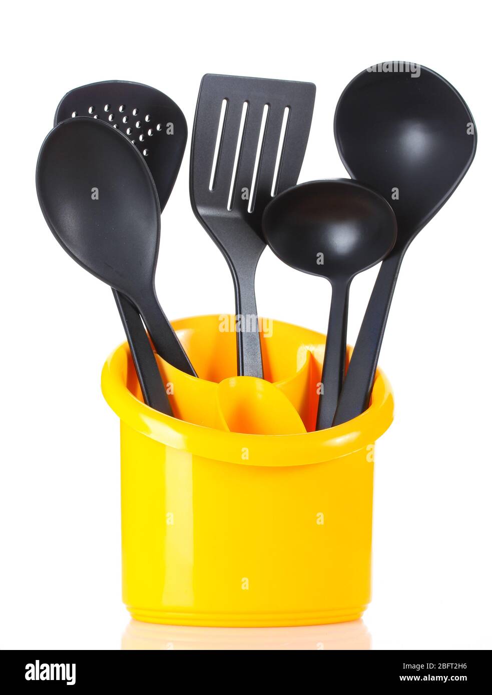 black kitchen utensils in yellow stand isolated on white Stock Photo