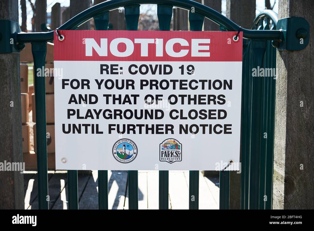 Empty playground equipment in Michigan due to COVID 19, Coronavirus showing the official notice that playground is closed Stock Photo