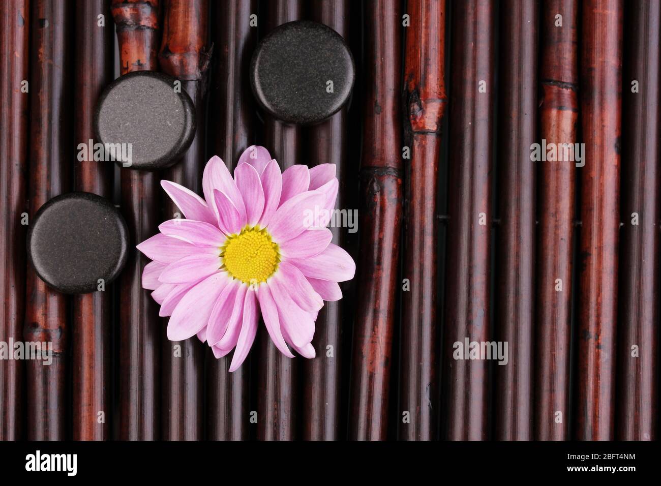 Spa stones and flower on bamboo mat Stock Photo - Alamy