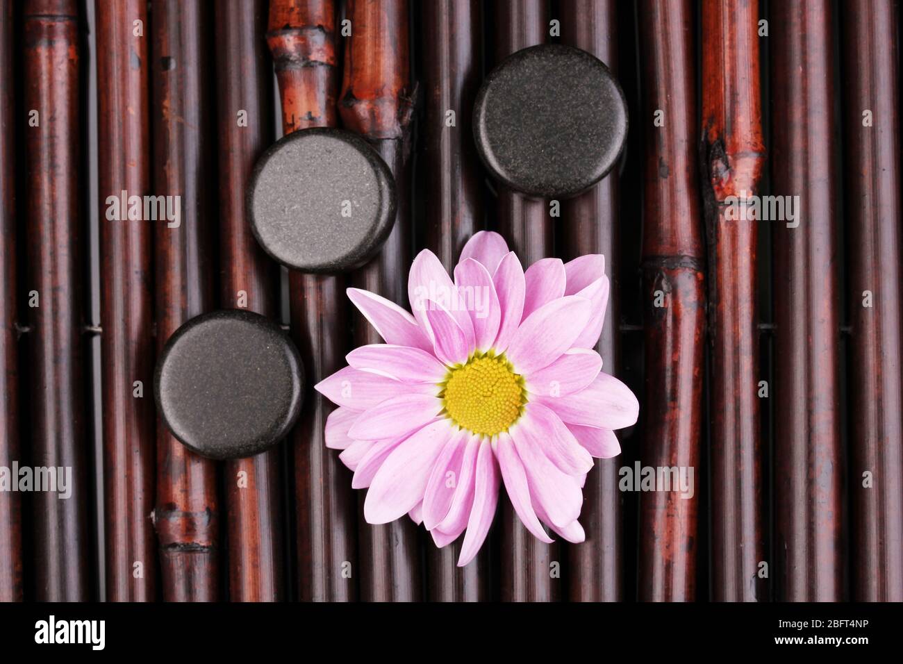 Spa stones and flower on bamboo mat Stock Photo - Alamy