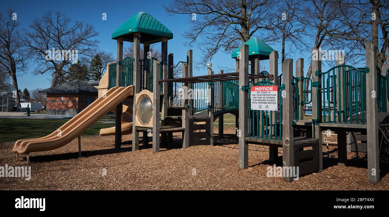 Empty playground equipment in Michigan due to COVID 19, Coronavirus showing the official notice that playground is closed Stock Photo