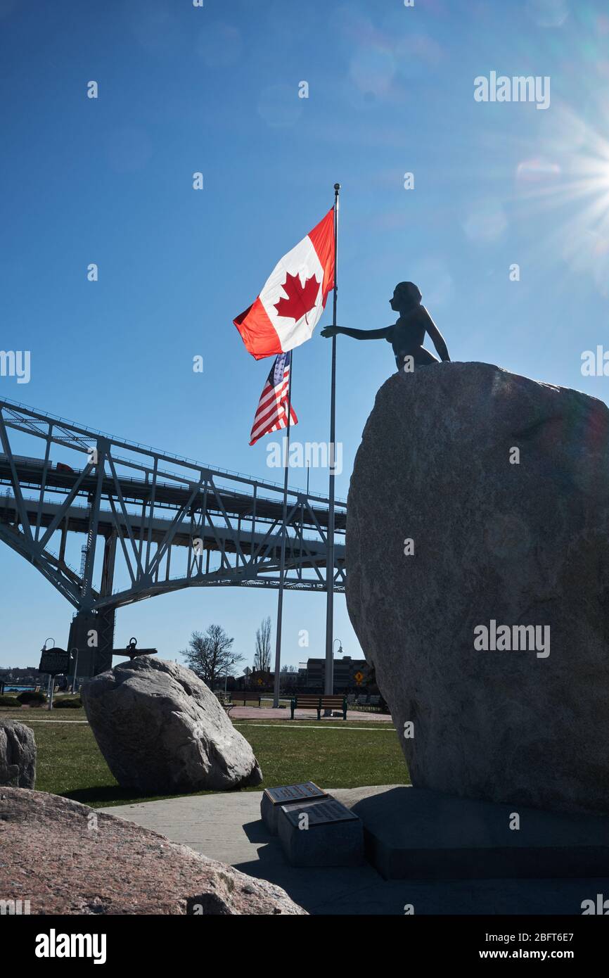 Blue Water Bridge International Crossing from USA to Canada on a sunny day showing USA and Canadian flags Stock Photo