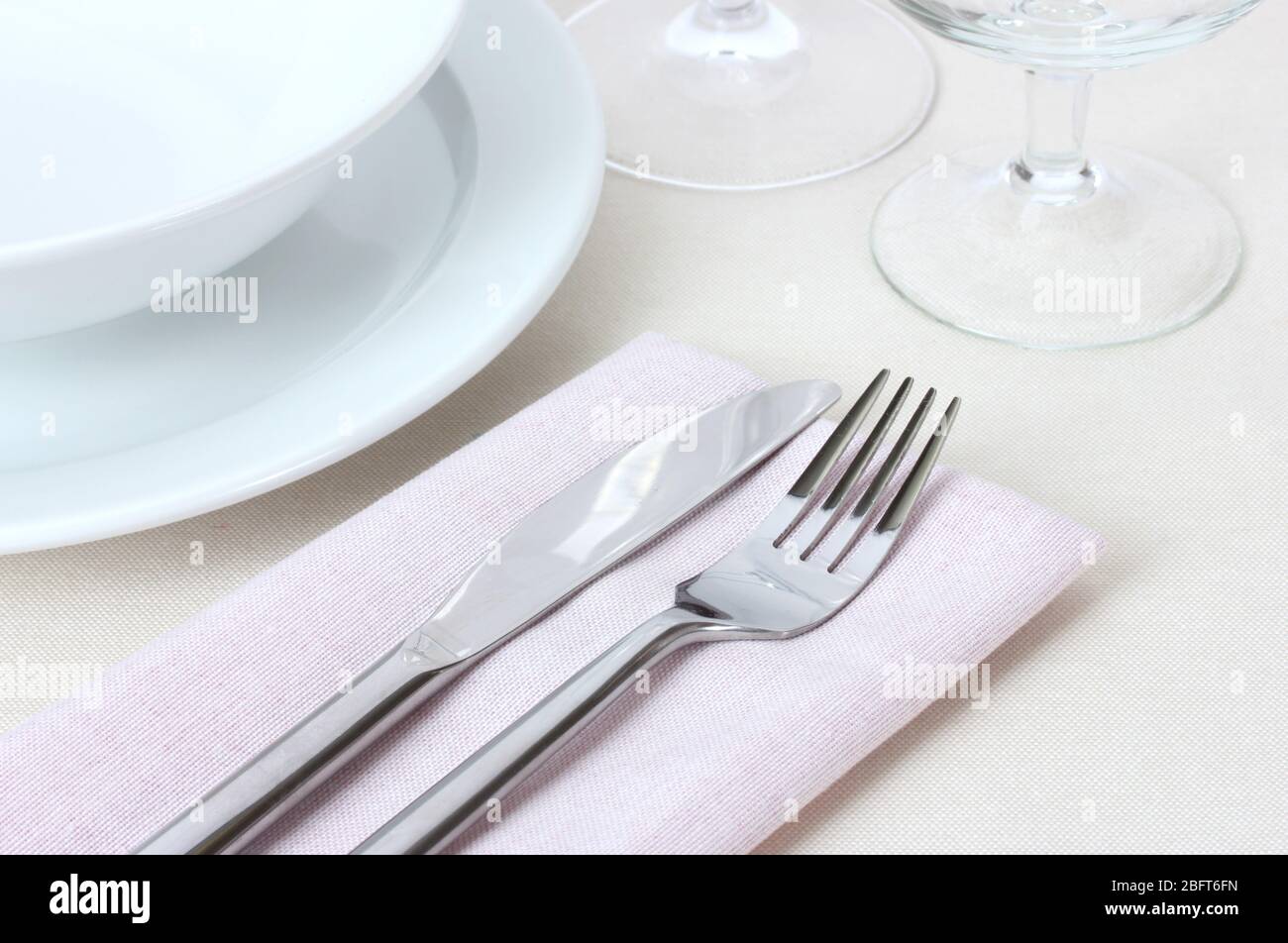 Table setting with fork, knife, plates and napkin Stock Photo - Alamy