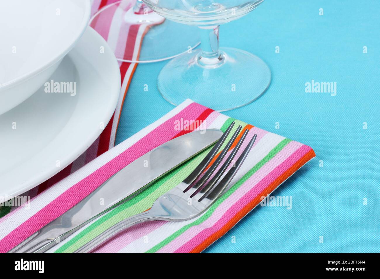 Table setting with fork, knife, plates, and napkin Stock Photo - Alamy