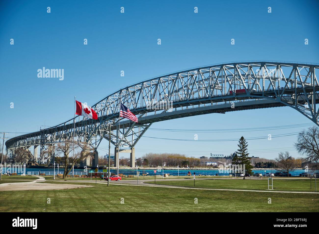 Blue Water Bridge International Crossing from USA to Canada on a sunny day showing USA and Canadian flags Stock Photo