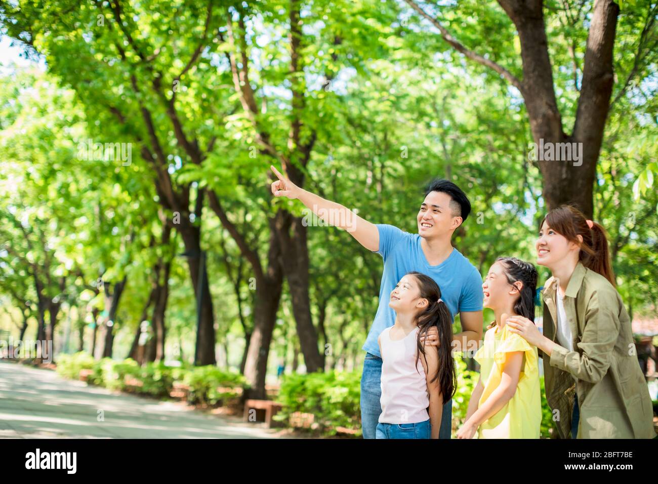 Happy family watching and  showing to something in the park Stock Photo
