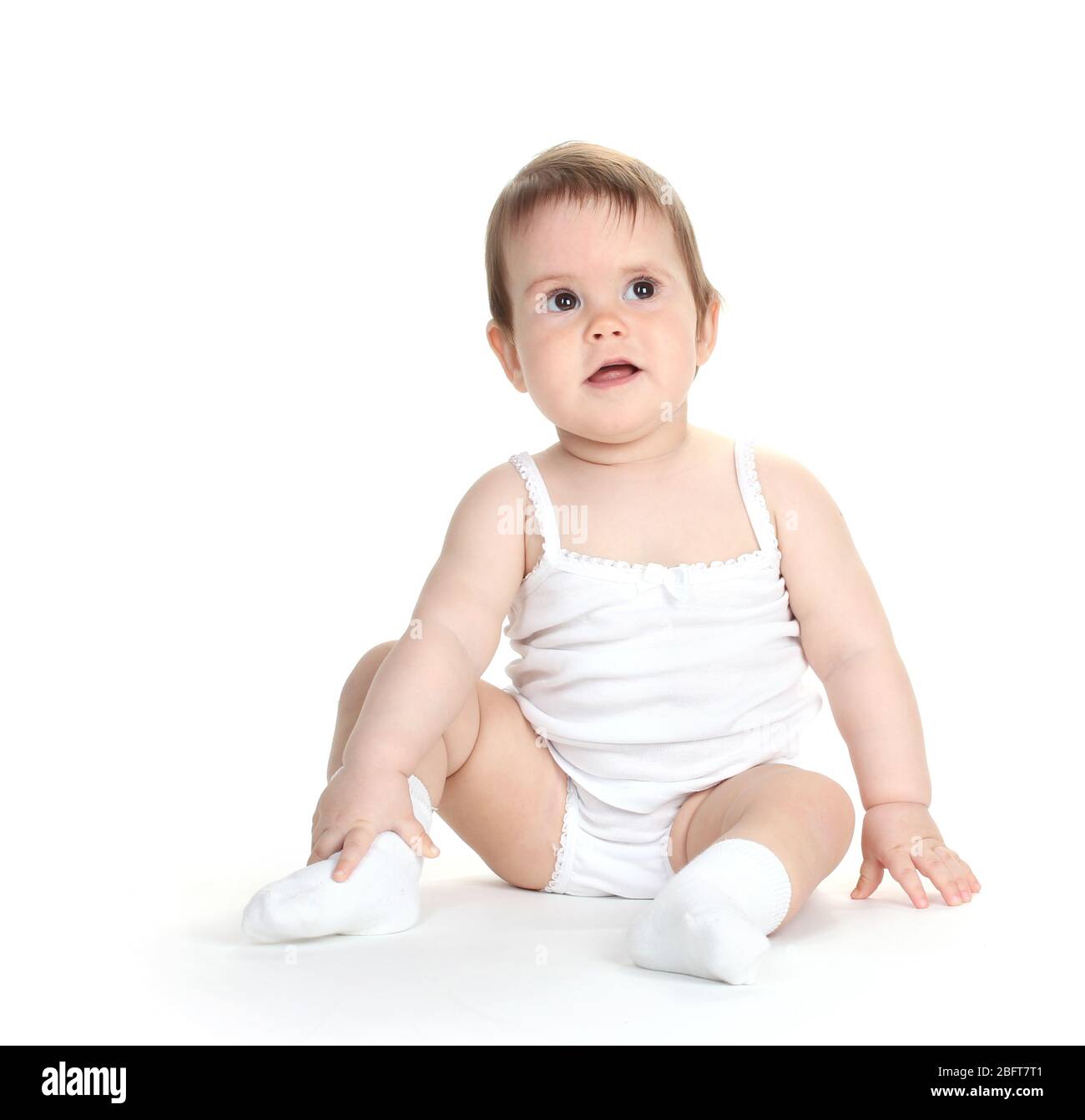 Cute baby girl sitting isolated on white Stock Photo - Alamy