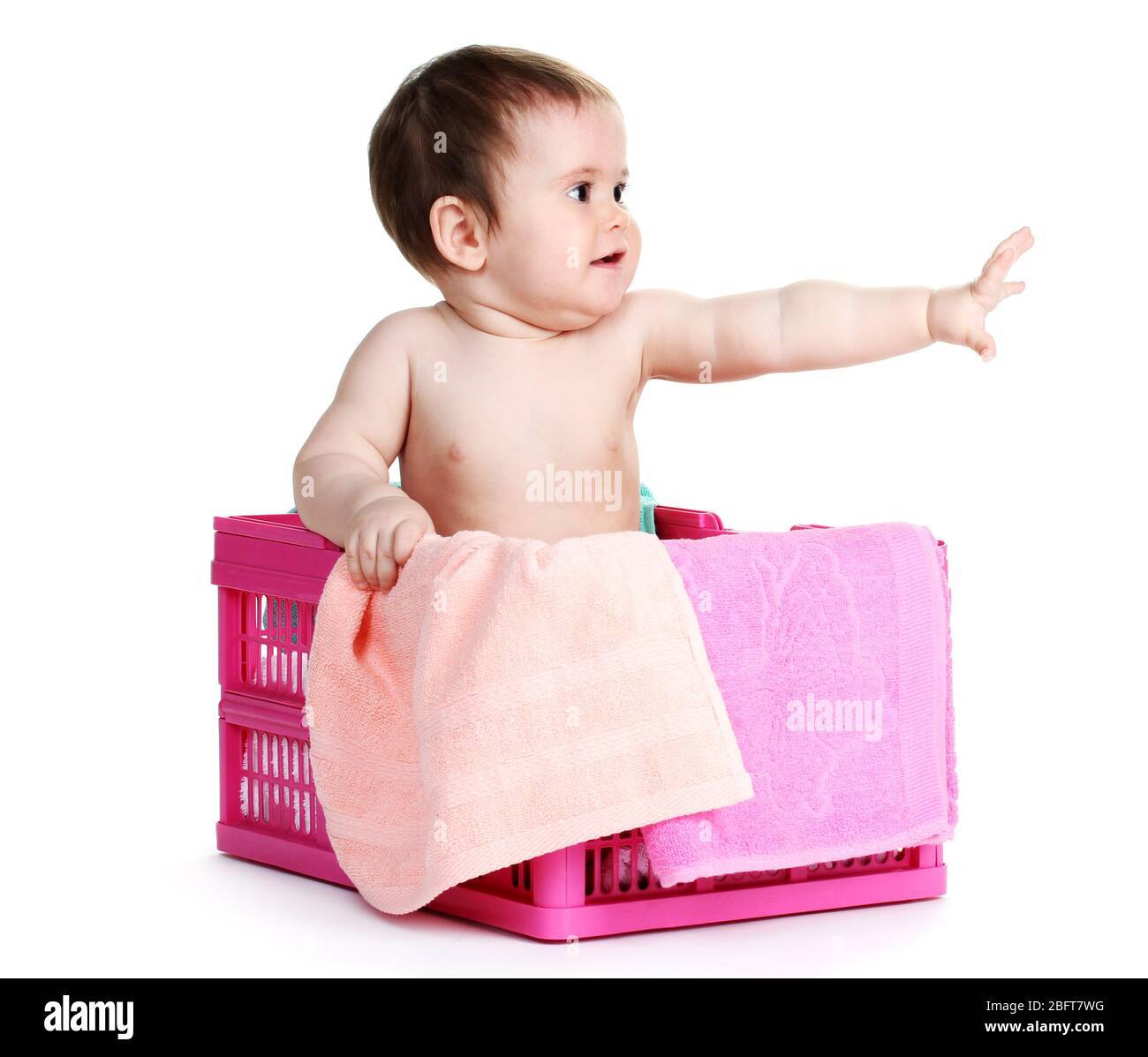 Cute baby girl sitting in laundry basket isolated on white Stock Photo