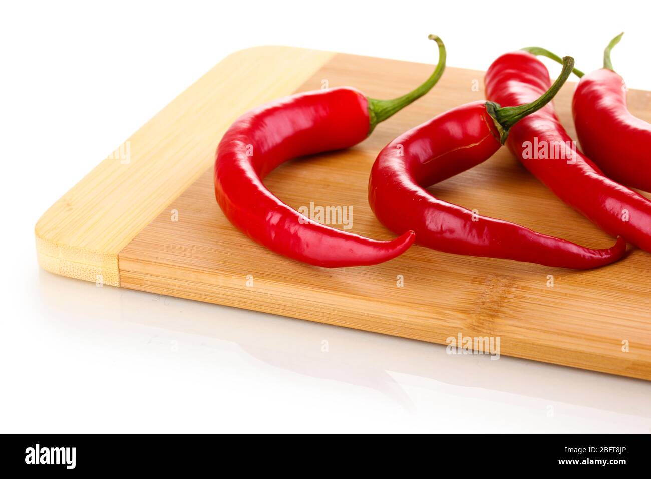Red hot chili peppers on wooden plank isolated on white Stock Photo - Alamy