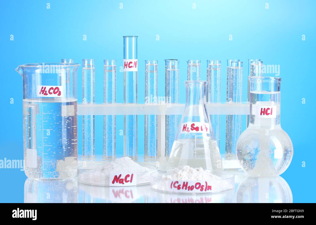 Test-tubes with various acids and chemicals on blue background Stock ...